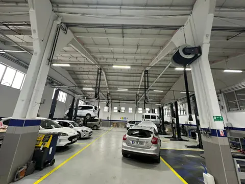 Binek araç servisinde lift başlarına monteli egzoz gazı tahliye makaraları